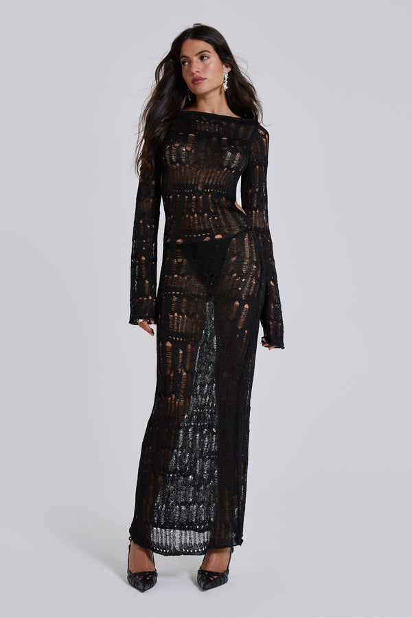 Female model wearing a black shredded, laddered knitted long sleeve maxi dress with sequin details. 