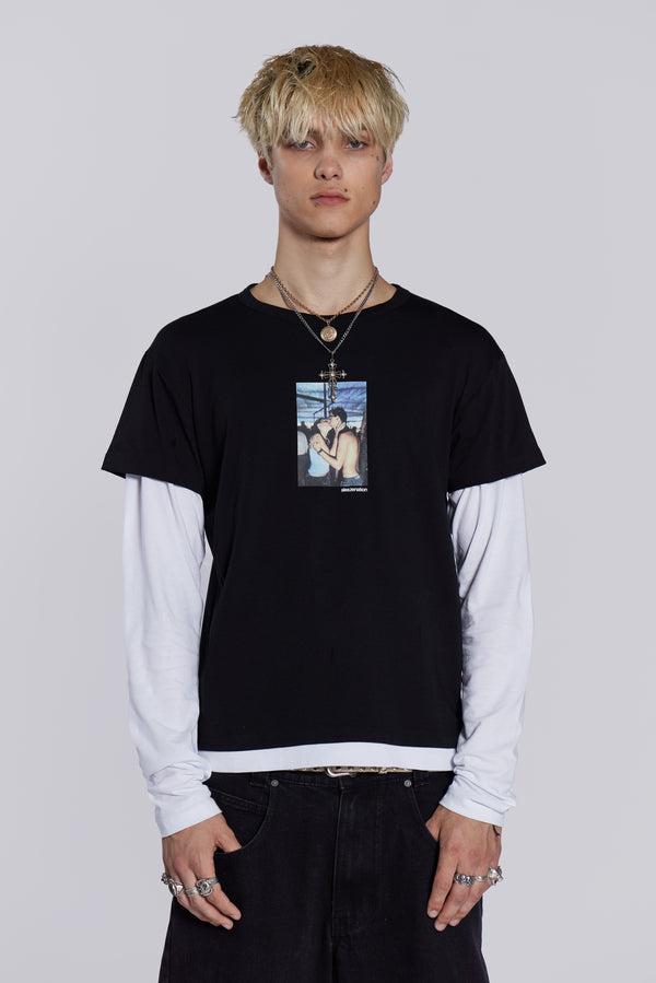Man wearing graphic print double layer t-shirt, styled with black denim jeans/