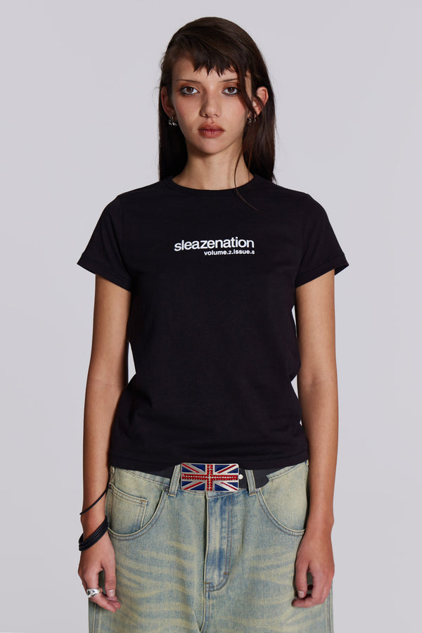 Woman wearing black slogan t-shirt, styled with blue denim jeans and union jack belt.