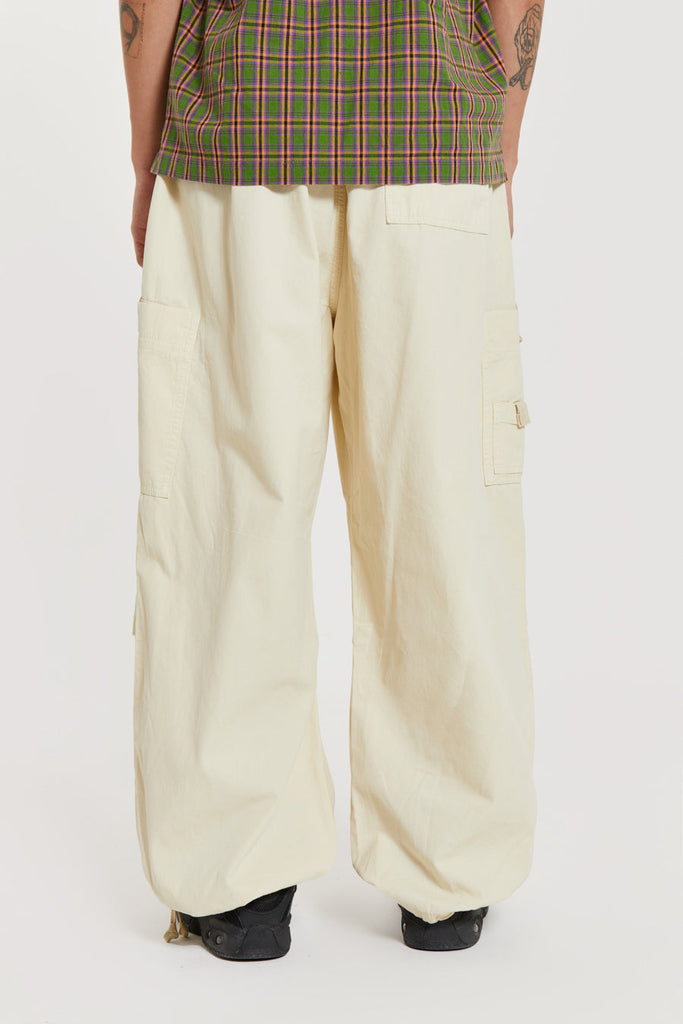 Unisex ecru oversized fitted parachute style cargo trousers with six pocket styling. 
