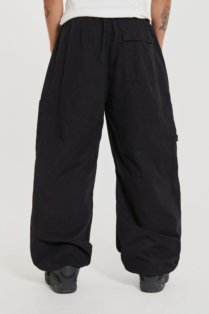 Unisex black oversized fitted parachute style cargo trousers with six pocket styling. 