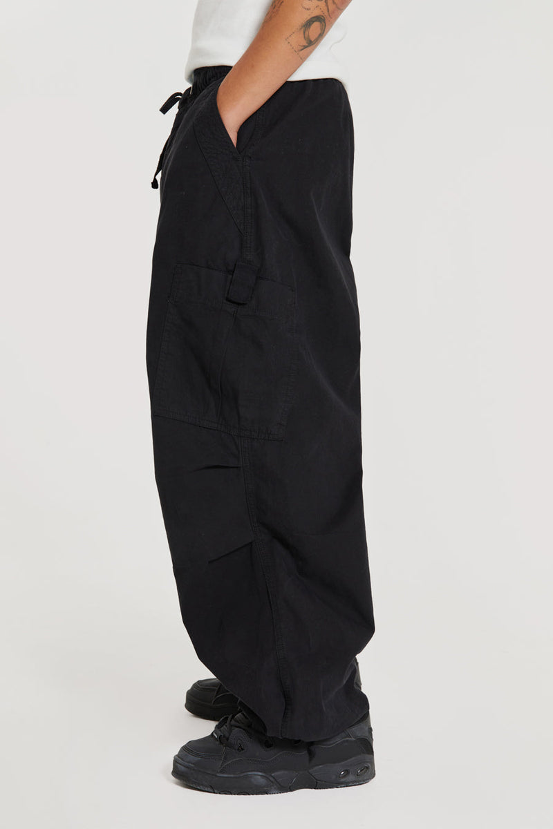 Unisex black oversized fitted parachute style cargo trousers with six pocket styling. 