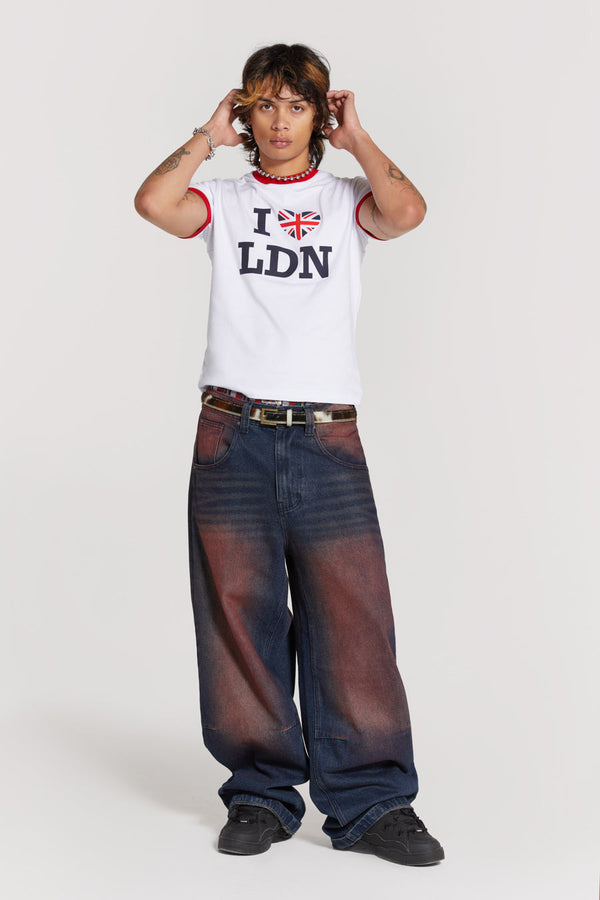 Male wearing red sandblast oversized fit colossus jeans. Styled with white short sleeve I love London t-shirt.