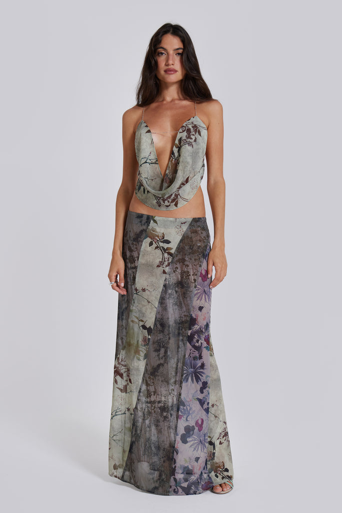 Female model wearing a floral maxi length skirt with panelled patchwork detail. Styled with the matching cowl neck top. 