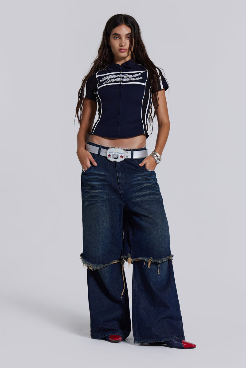  Female model wearing blue indigo baggy, loose fit denim jeans with a double layer effect. Styled with a navy t-shirt.