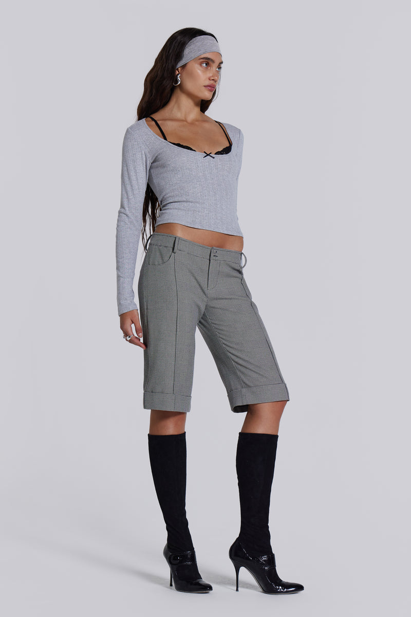 Female model wearing a grey marl long sleeve pointelle fabric with rib binding and needle neckline finish with a lace insert. 