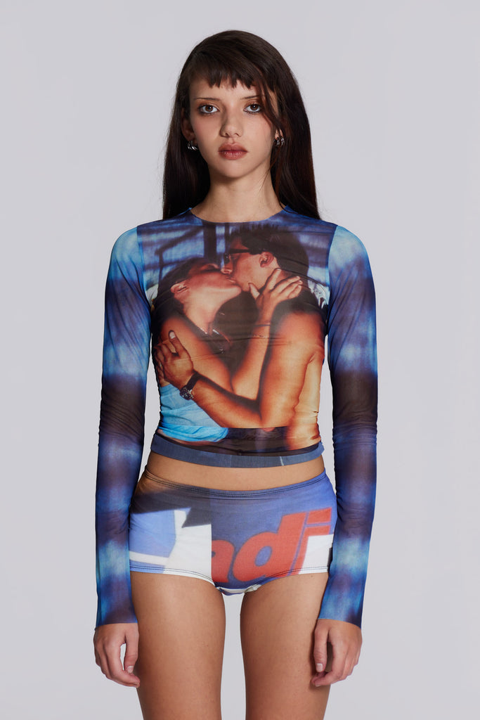 Female model wearing long sleeve powermesh top with kissing couple graphic print.