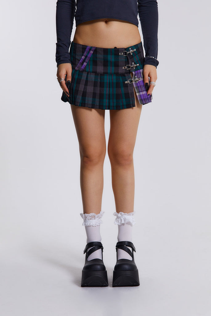 Female model wearing blue, green and purple checked mini kilt with pleats and buckle detail. 
