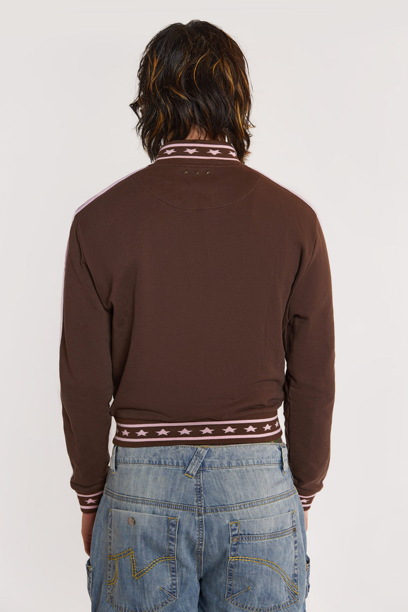 Male model wearing Brown & Pink Track Top with pink stripe detail. 