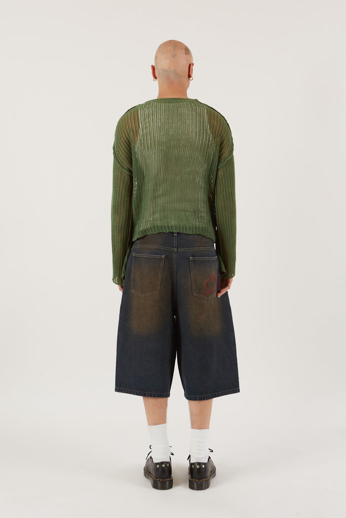 Male wearing Khaki Green Star Loose Knit Jumper.  Styled with blue oversized denim shorts.