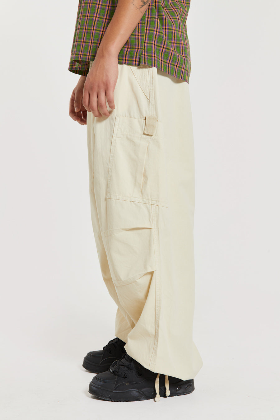 Unisex ecru oversized fitted parachute style cargo trousers with six pocket styling. 