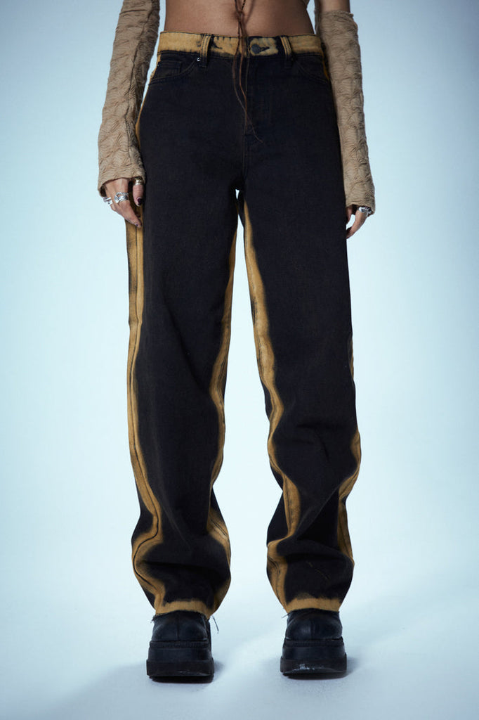 Washed Black Low Rise Baggy Fit Jeans With Burnt Yellow Seams & Hem styled with snake print boots.