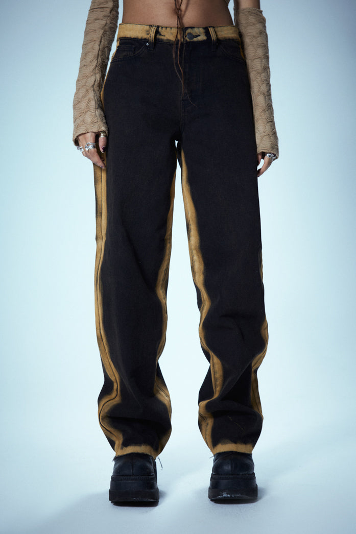 Washed Black Low Rise Baggy Fit Jeans With Burnt Yellow Seams & Hem styled with snake print boots.