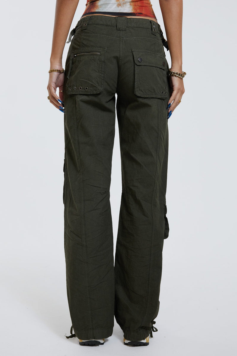 Female wearing khaki green slim fit low rise cargo trousers. Styled with bra illusion printed vest top. 