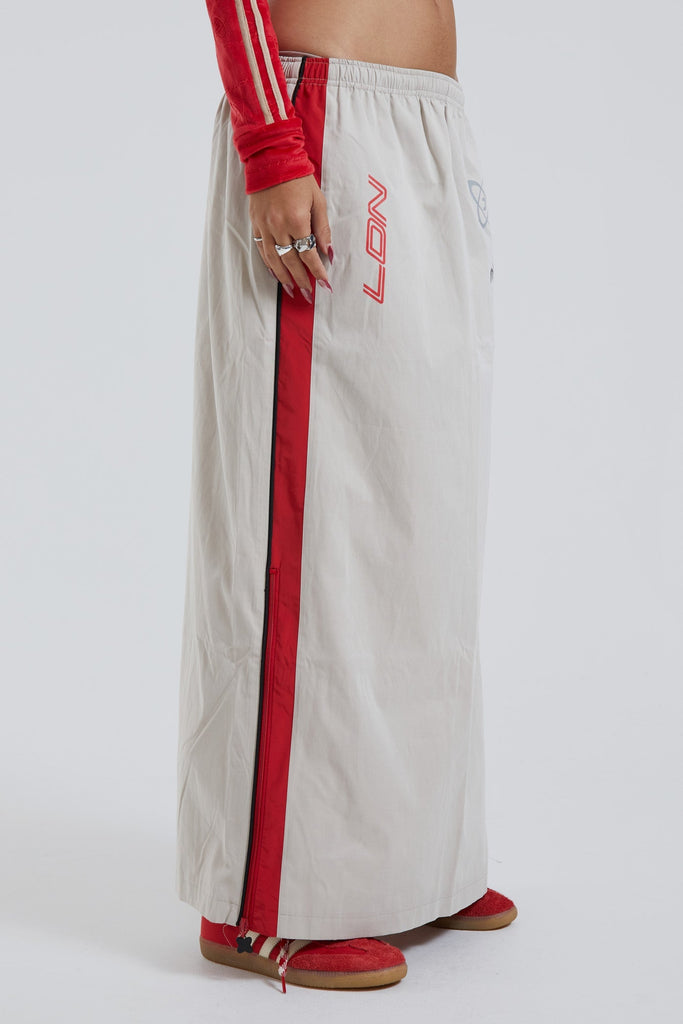 Female wearing red and almond track style midi length skirt. 