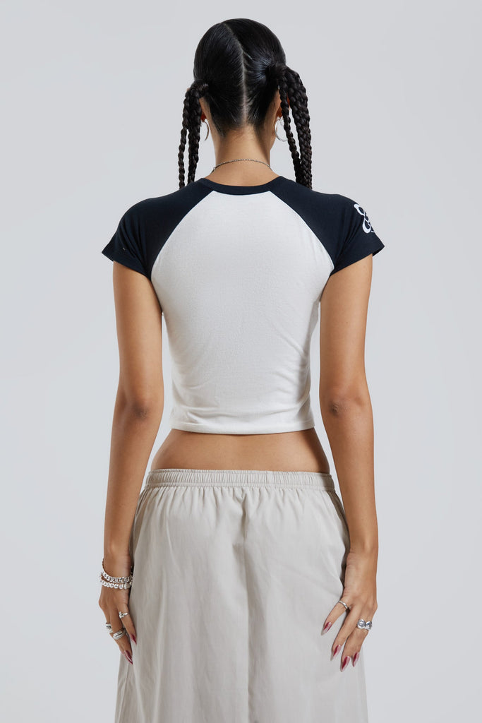 Female wearing white and black baby style cropped t-shirt with sporty style front graphic. 