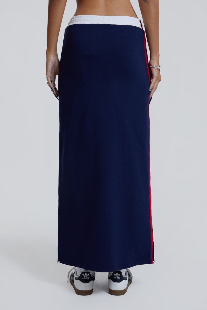 Female wearing navy sporty midi length skirt with toggle waistband detail. 