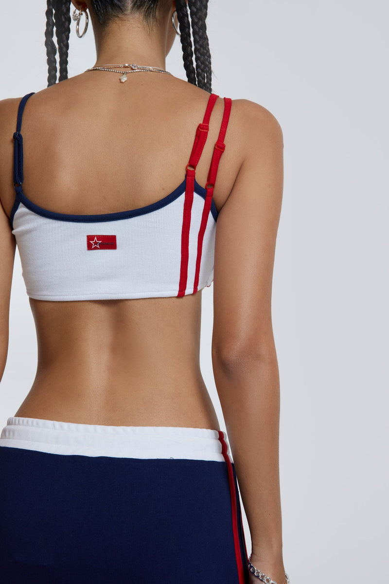 Female wearing white double strap sporty extreme crop top. 