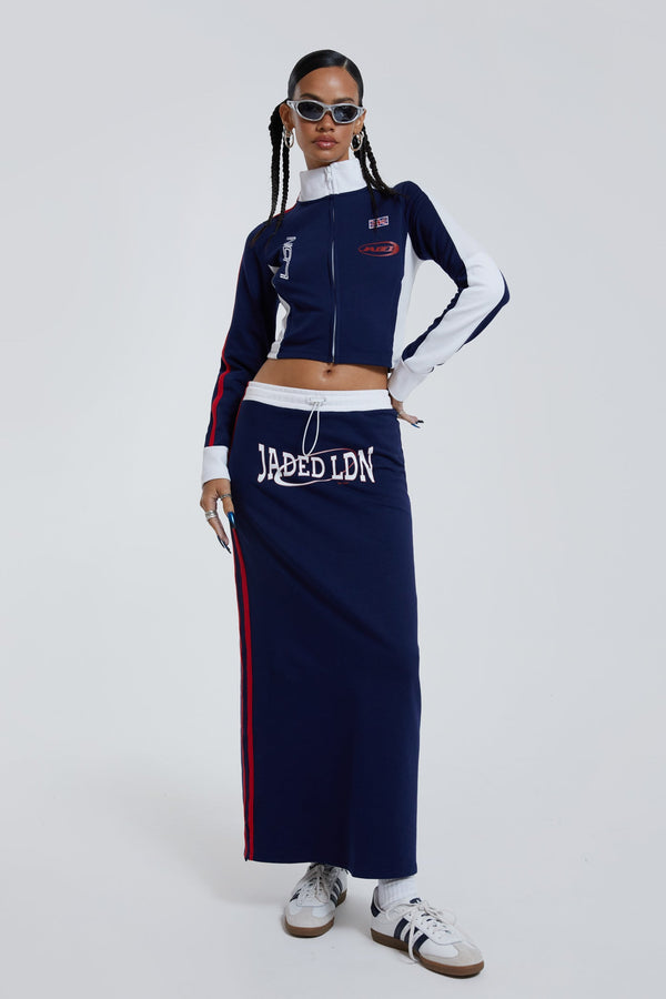 Female wearing navy sporty midi length skirt with toggle waistband detail. 