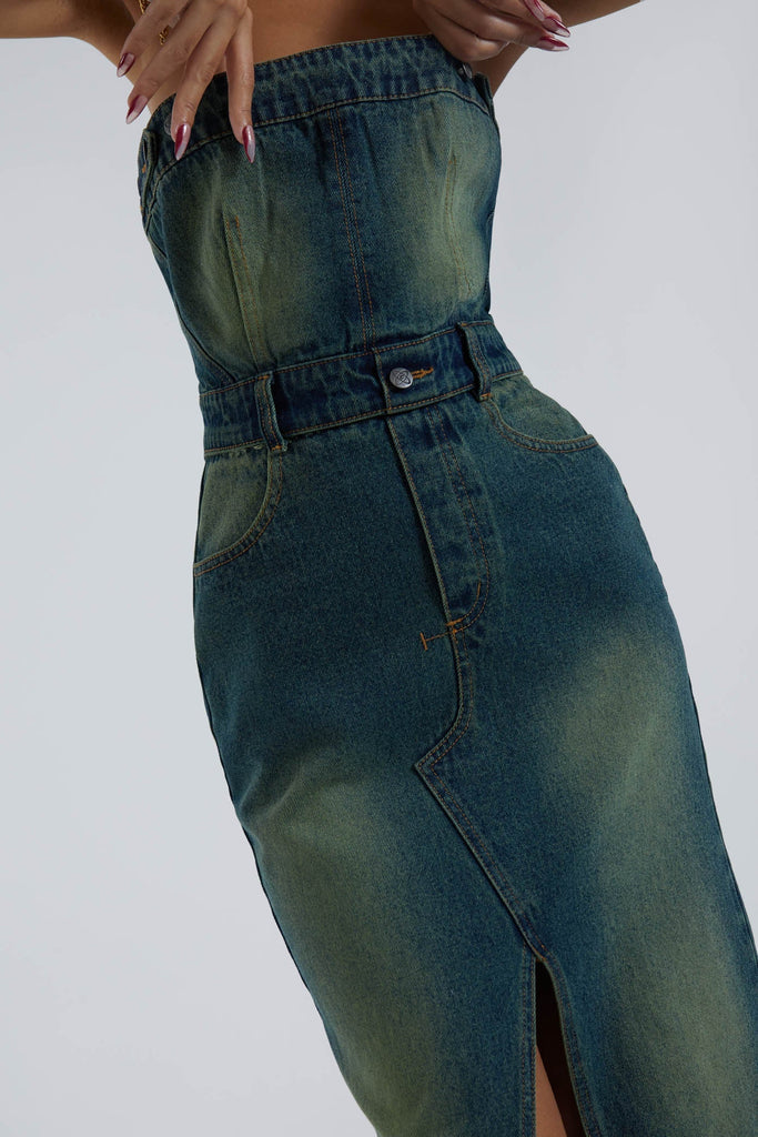 Female wearing blue bandeau denim corset maxi length dress with front split detail. 