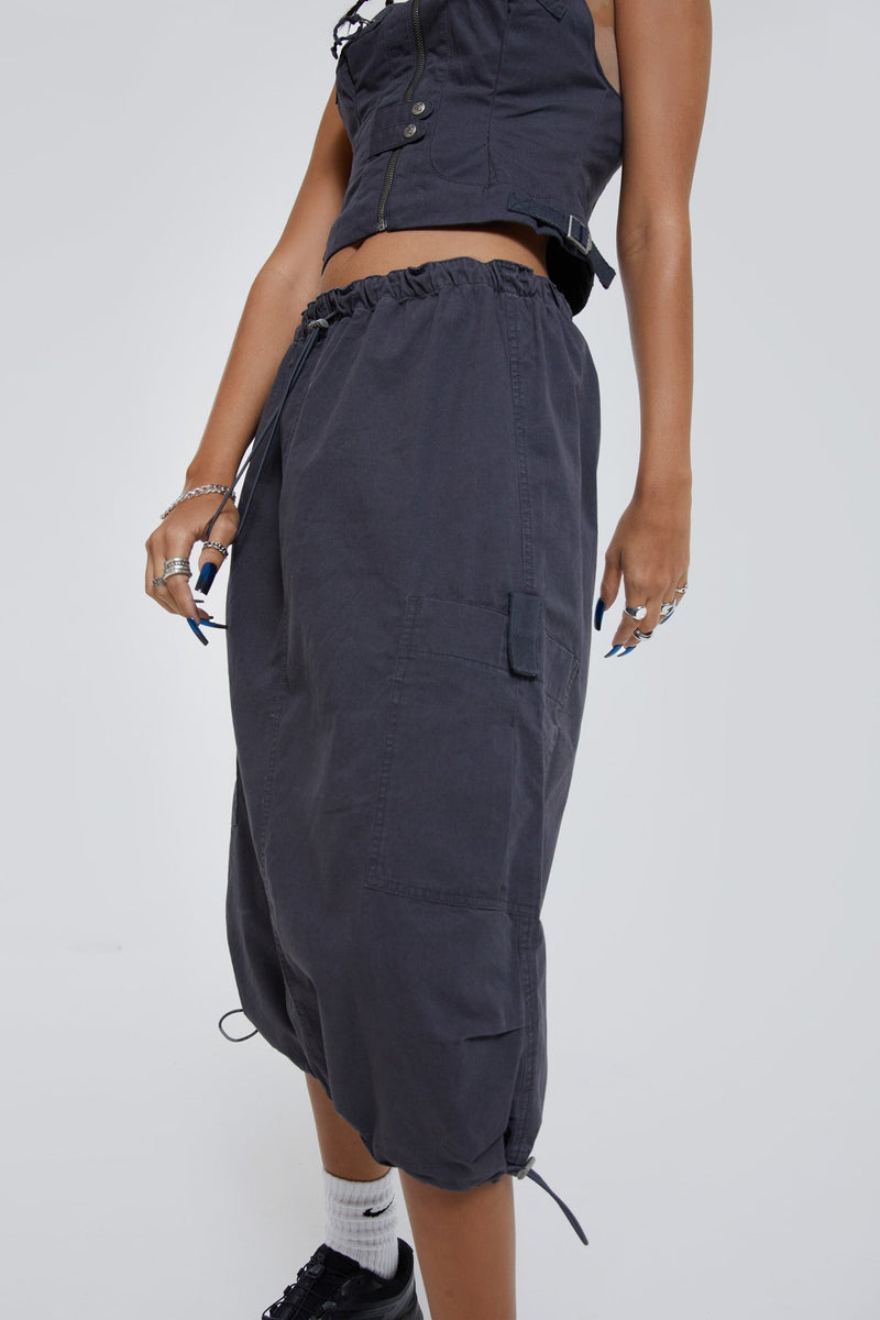 Female wearing grey cargo parachute style maxi skirt. 