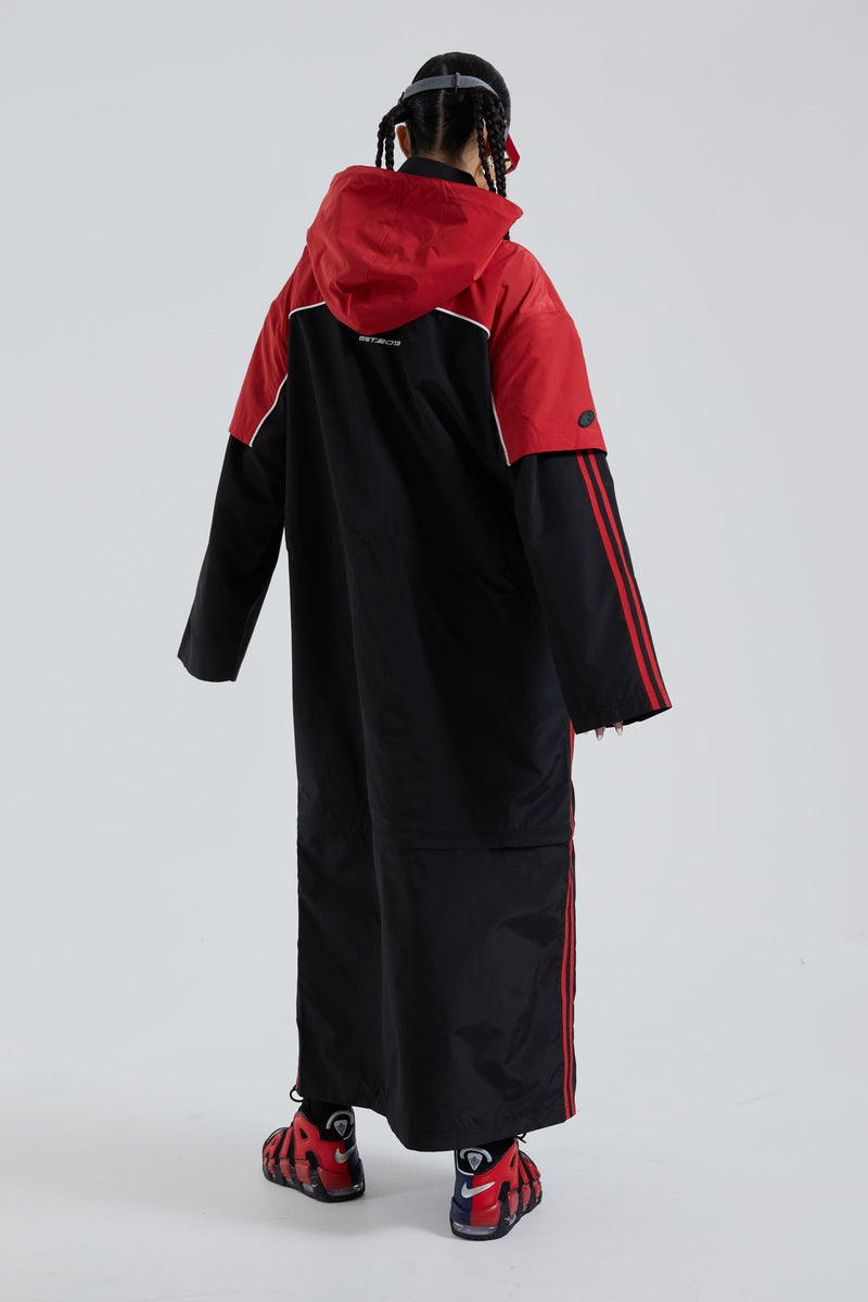 Female wearing red & black maxi length long sleeve sporty cagoule coat.