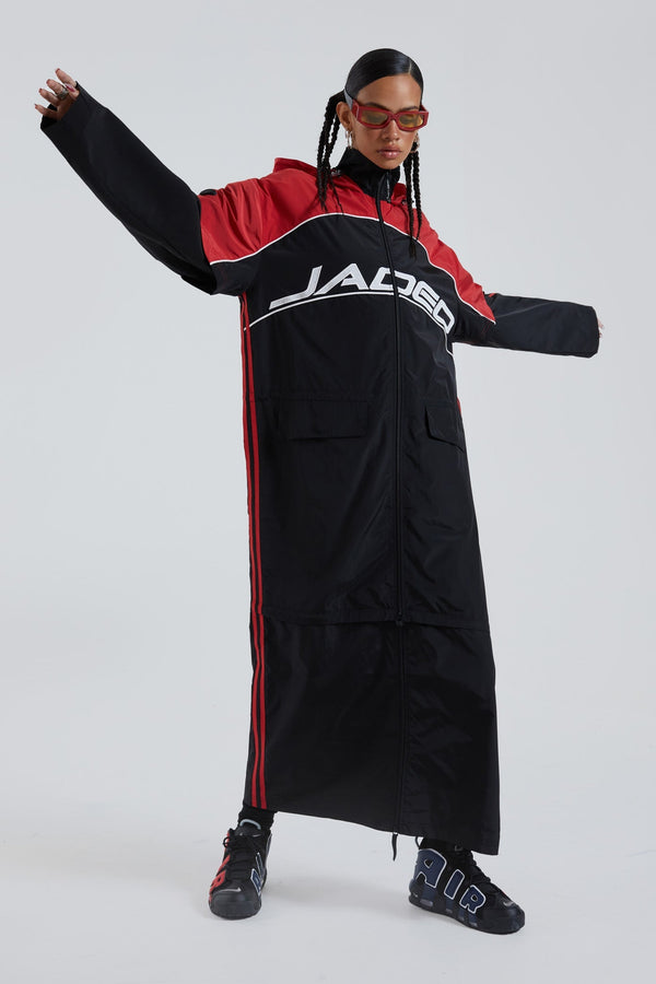 Female wearing red & black maxi length long sleeve sporty cagoule coat.