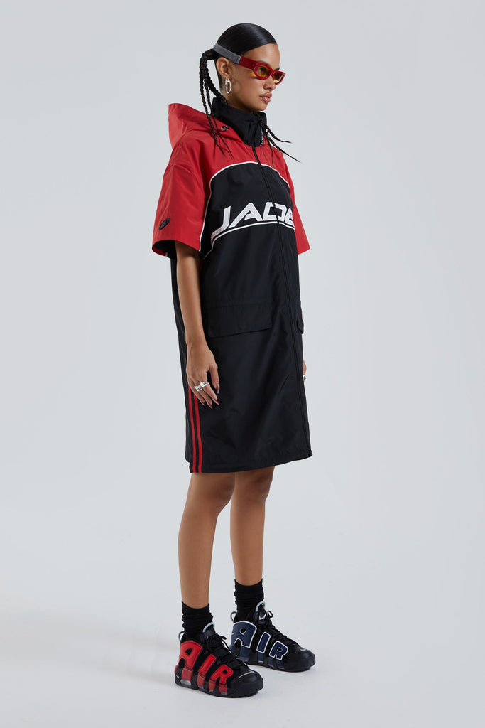 Female wearing red & black knee length short sleeve sporty cagoule coat. 