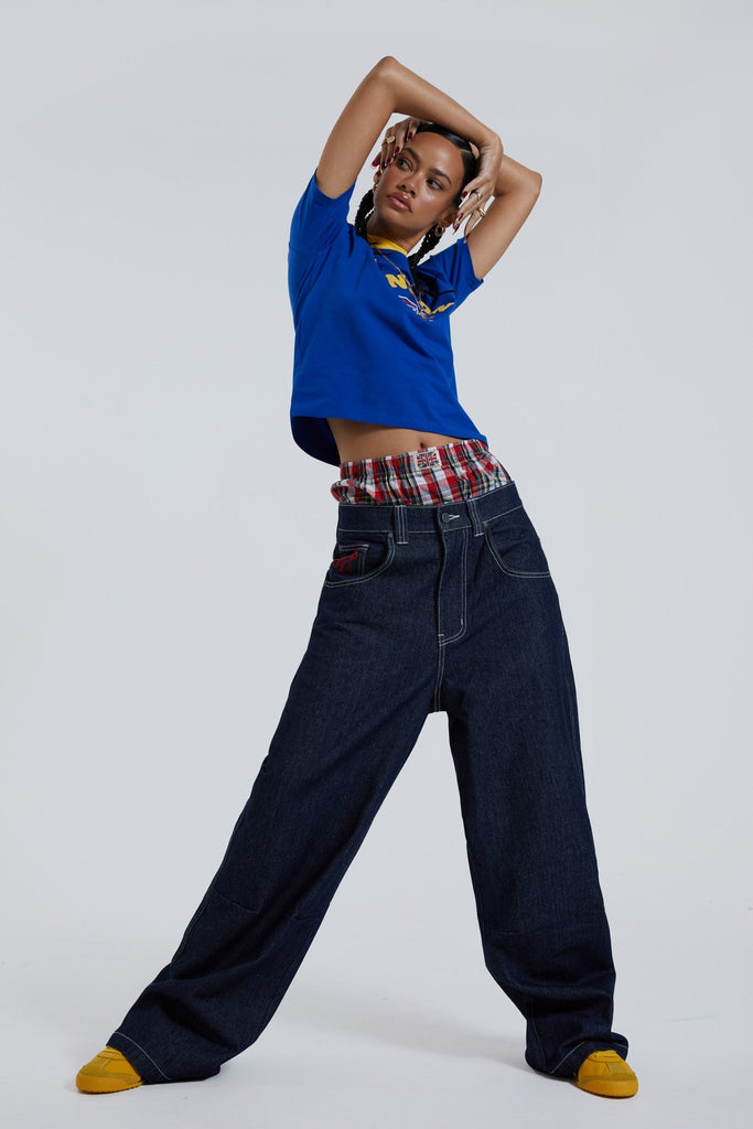 Female wearing sandblast washed denim jeans in an oversized skate fit with embroidered coin pocket and Union Jack artwork across back body and pockets. 