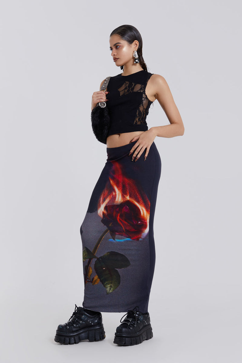 Female model wearing Black Tank Top With Cross Lace Detail styled with flaming rose print maxi length skirt.