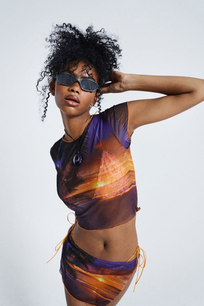 Female wearing Sunset Print Vintage Mesh Split Mini Skirt styled with the matching cropped baby tee. 