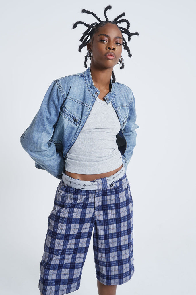 Female model wearing blue checked cord jorts in a jumbo fit. 