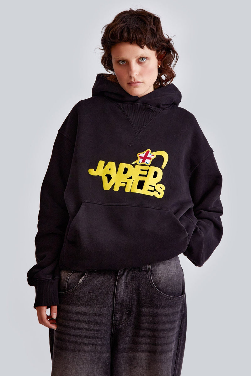 Female wearing a black oversized hoodie with yellow screenprint Jaded x Vfiles logo. 