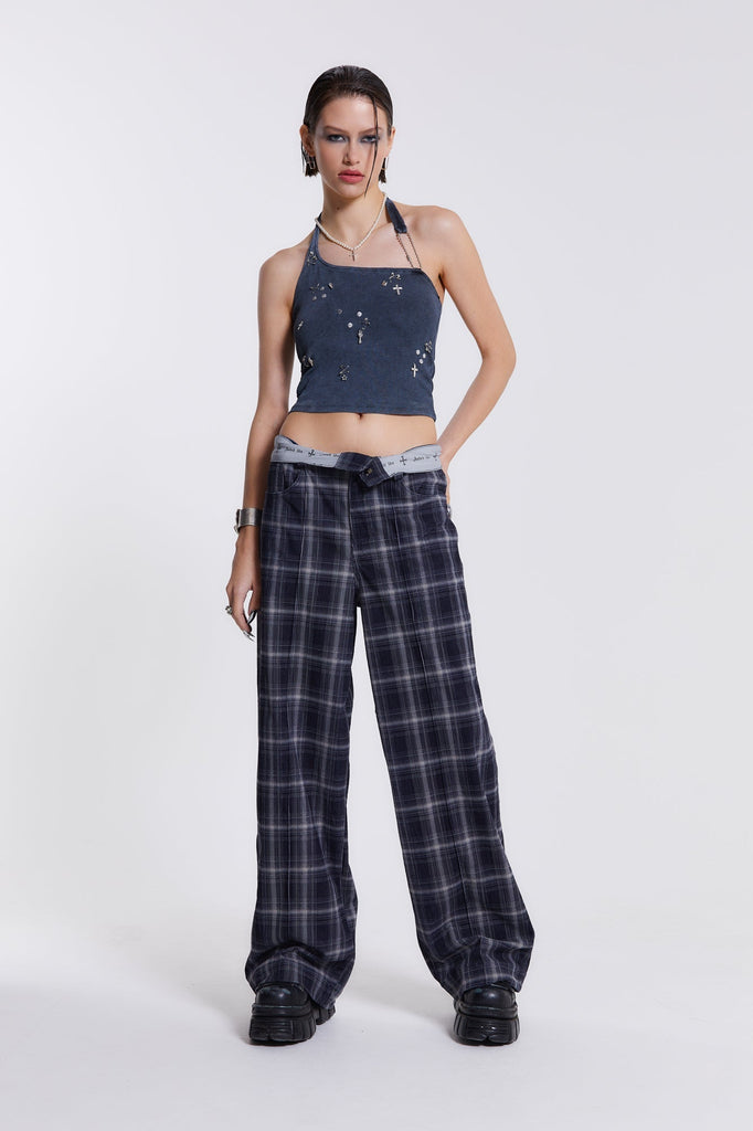 Female model wearing wide leg blue and white checked trousers with a fold over waist detail. 