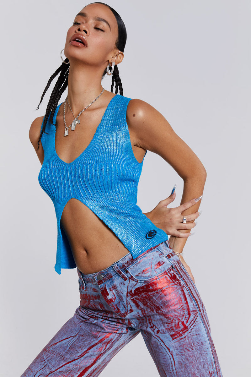 Female wearing blue metallic knitted v-neck sliced top. Styled with blue and red metallic distressed jeans. 
